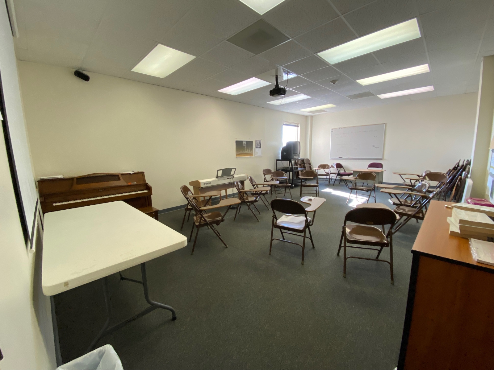 Room 219 has student desks, a whiteboard, a piano, and a table.